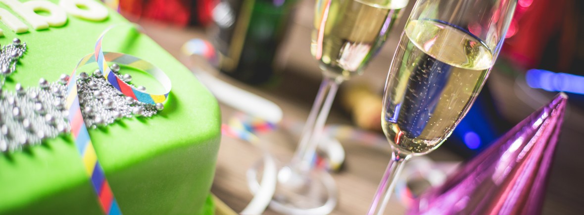 table d'anniversaire avec gateau et verres de champagne et cotillons